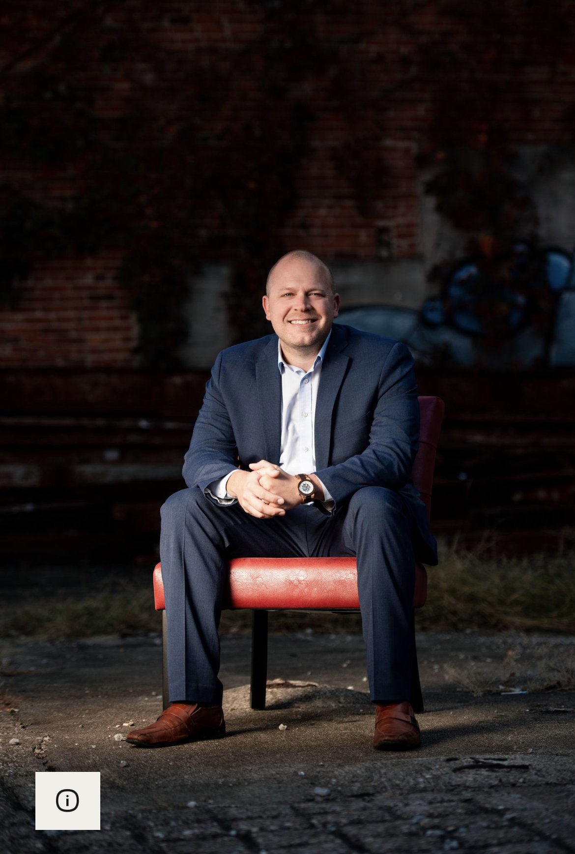 Christopher Wise, seated on a red chair in a Louisville industrial setting.